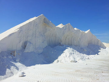 Large mounds of diatomaceous earth stone in a sunny outdoor setting showcasing its natural formation