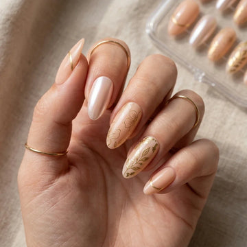 Nude pearl almond press-on nails with gold foil and floral detail