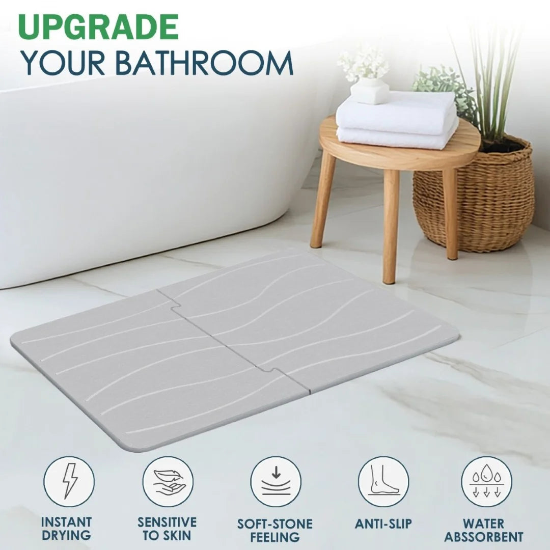 Gray bath mat with features listed, placed in a bathroom setting with a stool and plant.