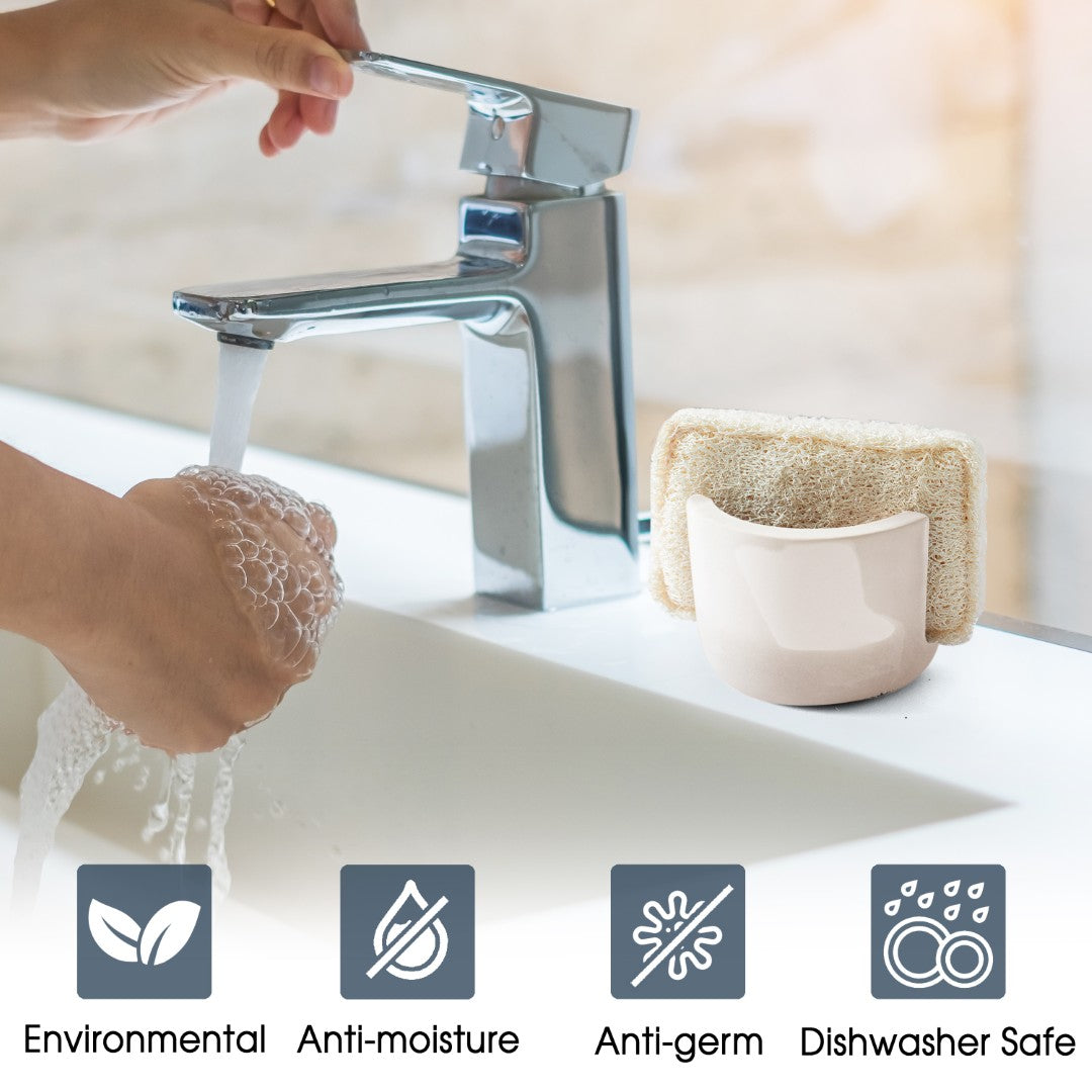 Person washing hands with soap under a faucet, with a sponge and cup on the sink.
