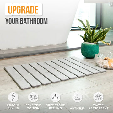 Gray bath mat on a bathroom floor with text 'Upgrade Your Bathroom' and product features listed.