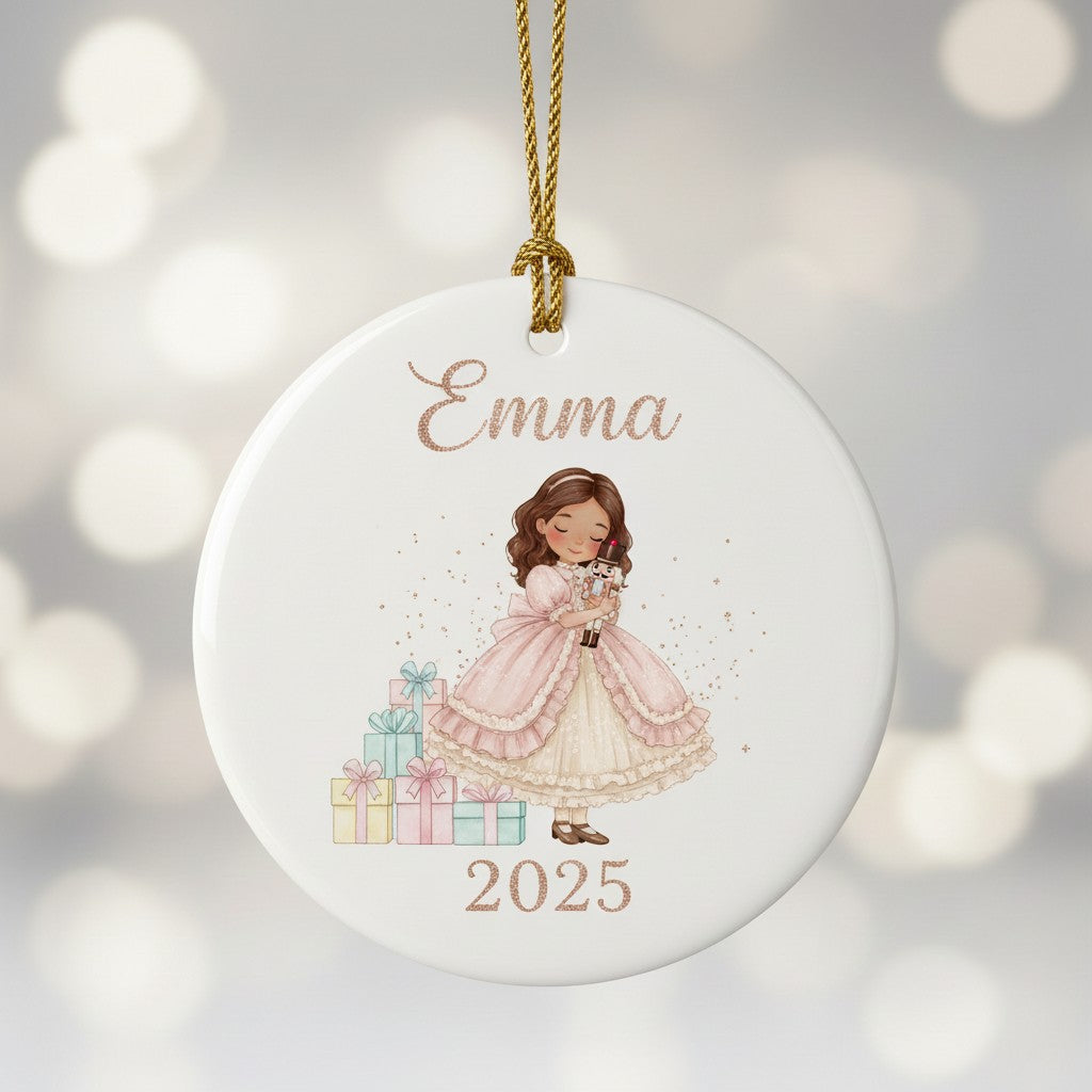 Decorative ornament with a girl holding gifts and the name 'Emma' and year '2025' on a blurred background.