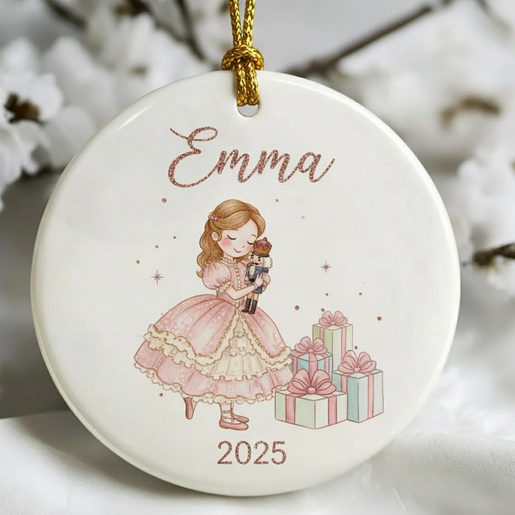 Decorative ornament with a girl holding a teddy bear and presents, labeled 'Emma 2025', against a white background.