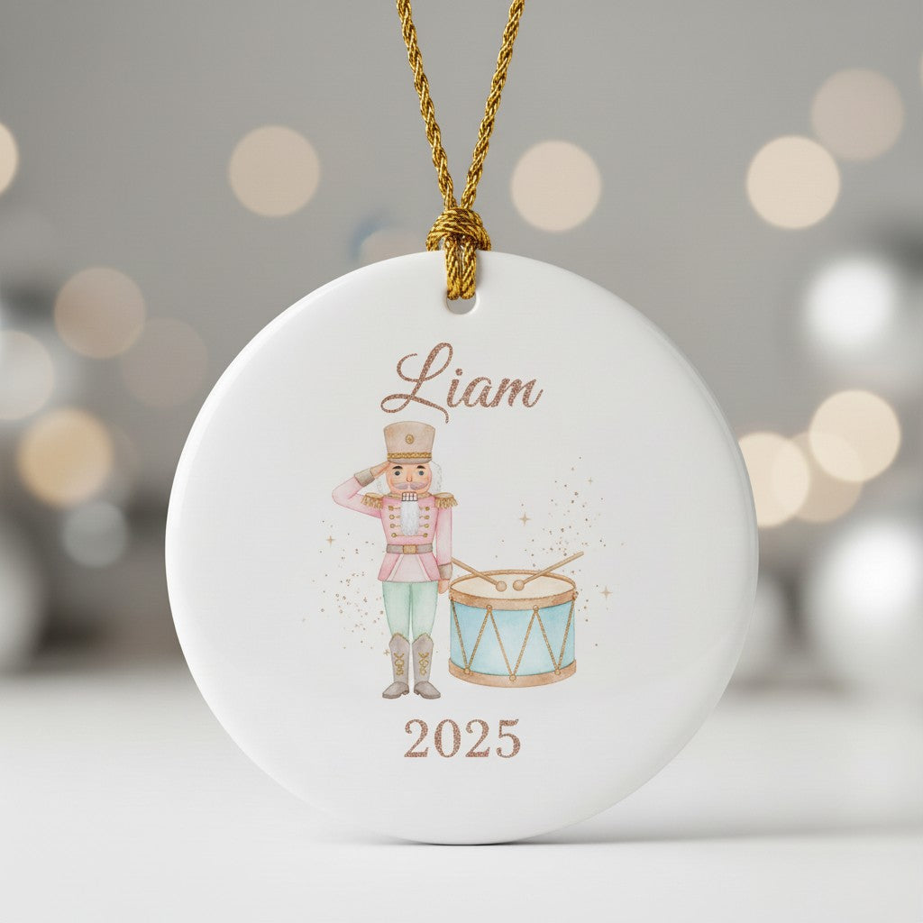Decorative ornament with a nutcracker design, 'Liam', and '2025' on a blurred lights background.