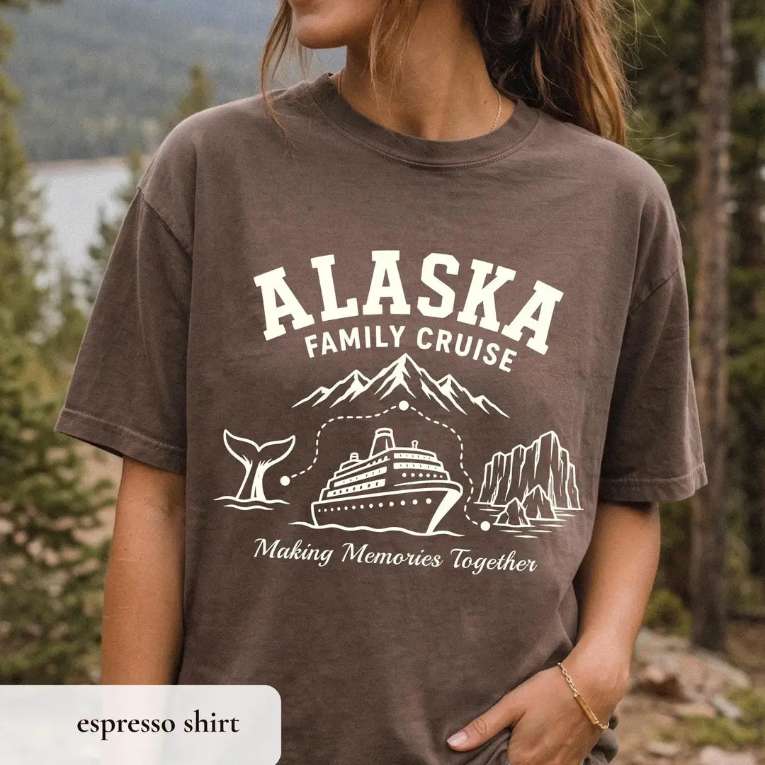 Woman in an Espresso brown Comfort Colors tee in a pine forest, cream Alaska Family Cruise with a whale tail and cruise ship
