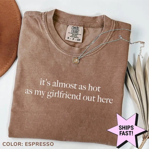 Folded Espresso brown Comfort Colors tee with the almost as hot as my girlfriend quote in light serif, brown hat beside it