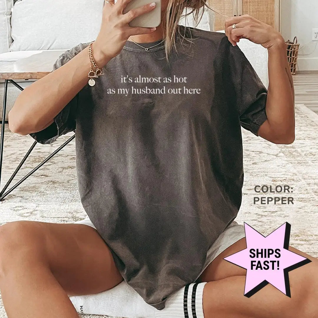 Woman in a Pepper Comfort Colors tee taking a mirror selfie, the almost as hot as my husband quote in small white serif
