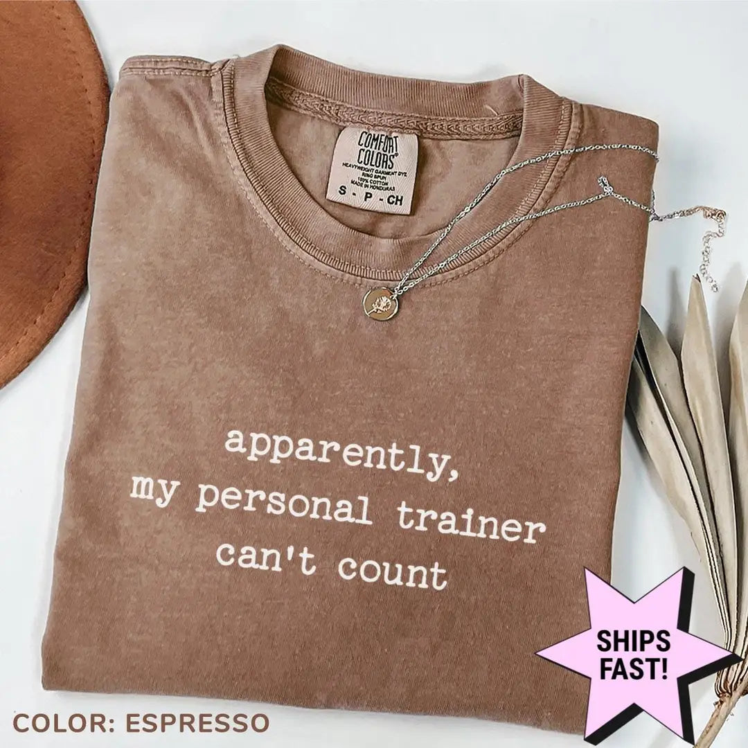 Folded Espresso brown Comfort Colors tee with the personal trainer can't count quote in light typewriter lettering