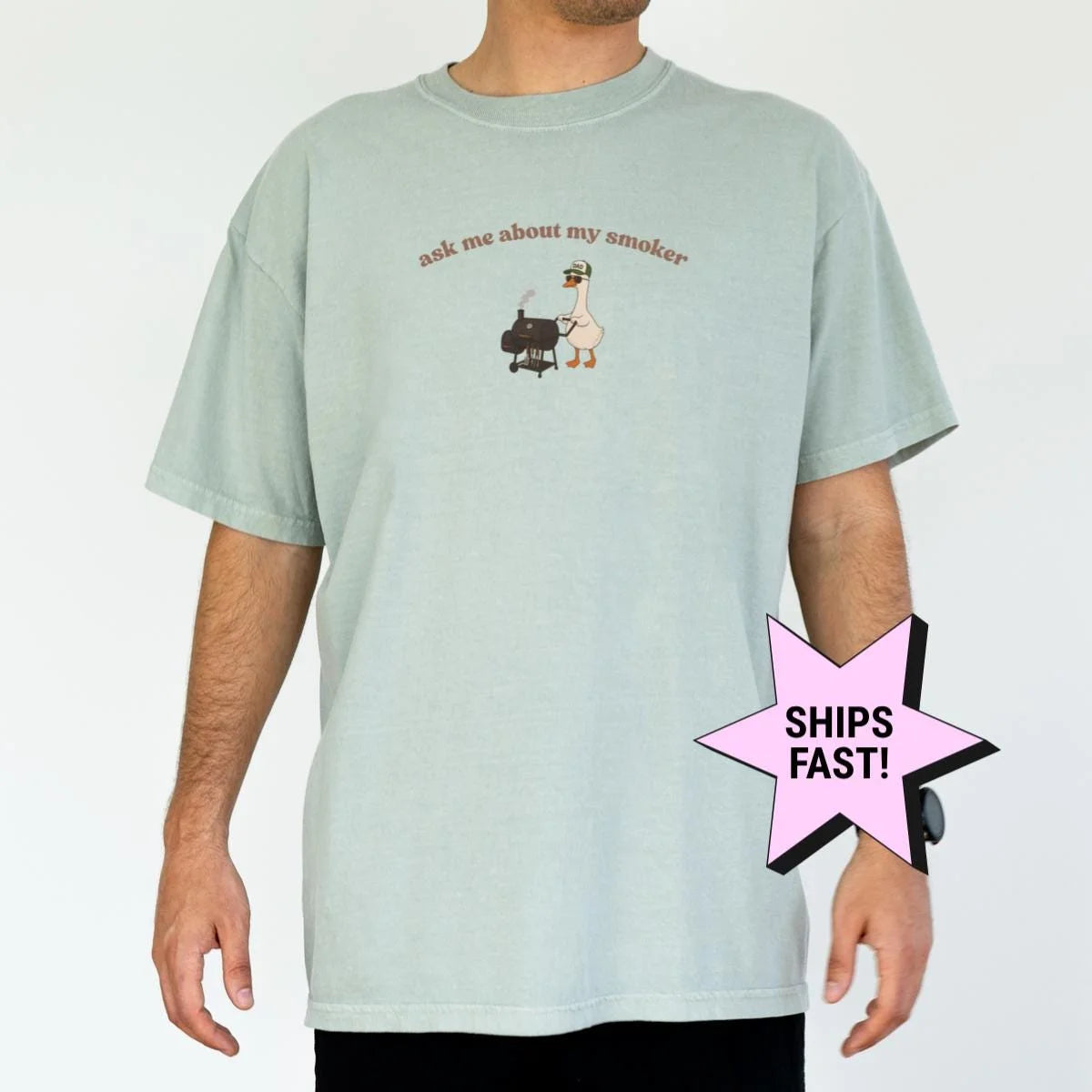 Man in a Seafoam Comfort Colors tee with the goose at a smoker and arched ask me about my smoker text on the chest