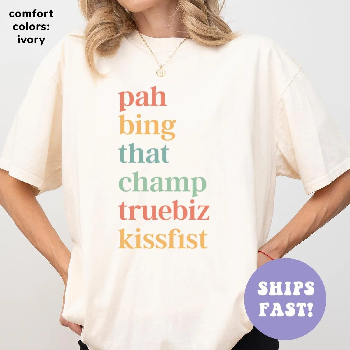 Woman in an Ivory Comfort Colors tee with pah, bing, that, champ, truebiz and kissfist stacked in coral, gold and sage