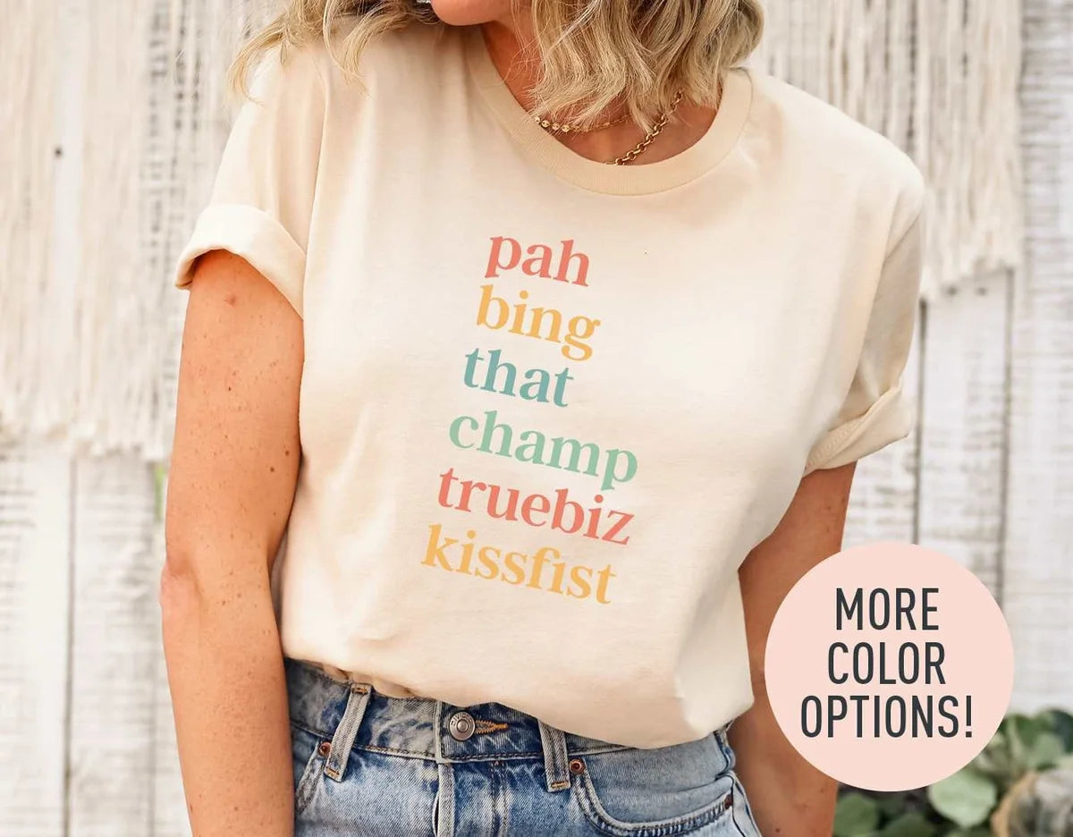 Woman in a natural cream tee with rolled sleeves and jeans, pah bing that champ truebiz kissfist stacked in coral and mustard