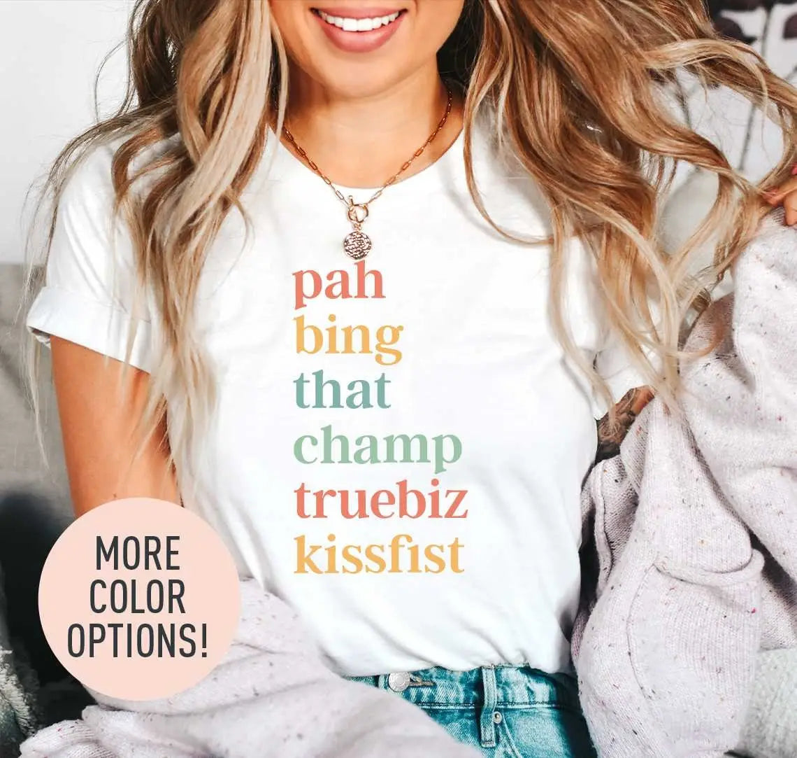 Woman in a white tee and a lilac cardigan, the stacked ASL words pah to kissfist in coral, mustard and sage serif