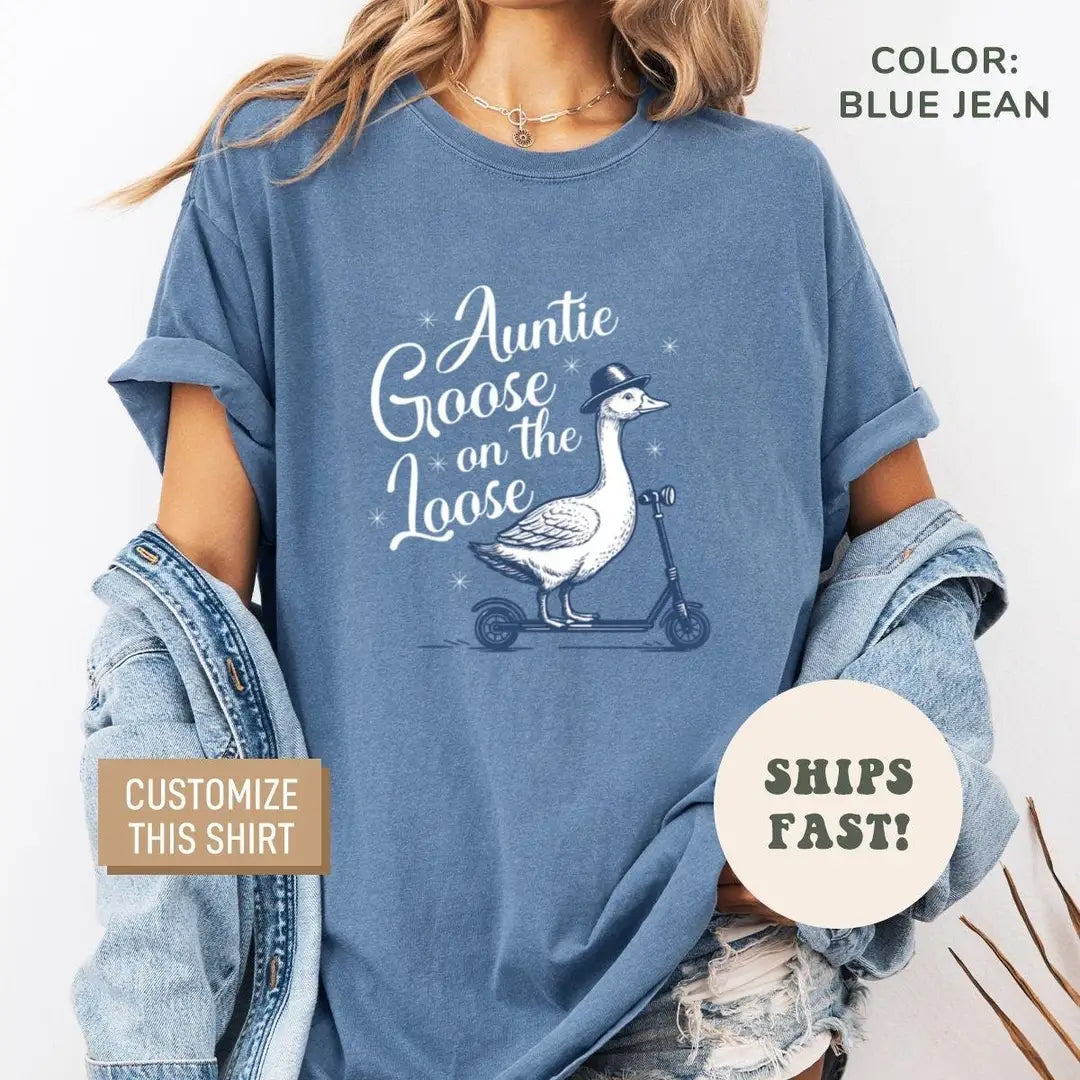 Woman in a Blue Jean Comfort Colors tee and a denim jacket with a goose on a scooter and Auntie Goose on the Loose