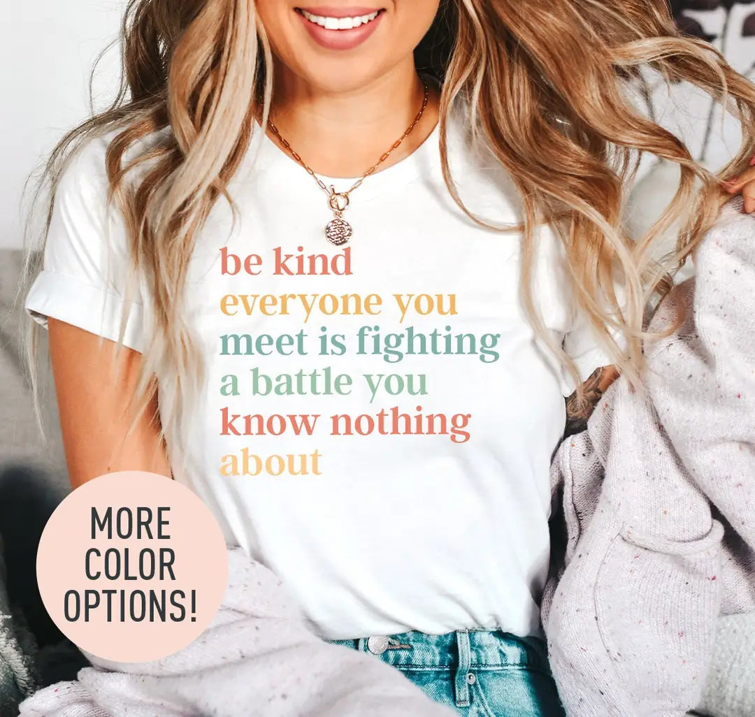Woman in a white tee and a lilac cardigan, be kind everyone you meet is fighting a battle quote stacked in warm serif