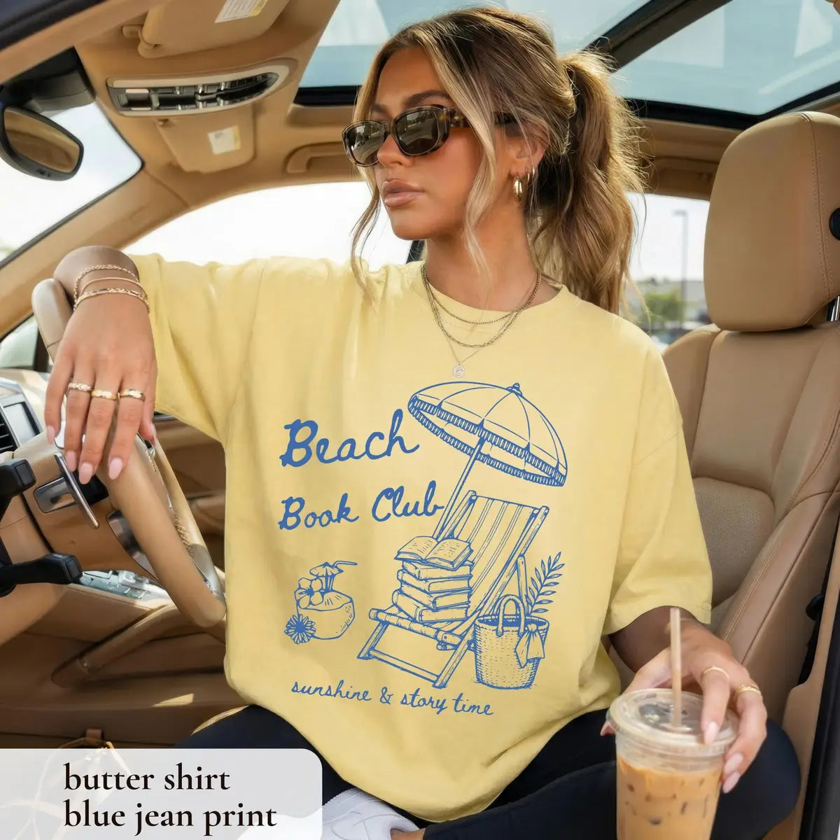 Woman in a Butter yellow Comfort Colors tee in a car with an iced coffee, blue beach book club and umbrella chair