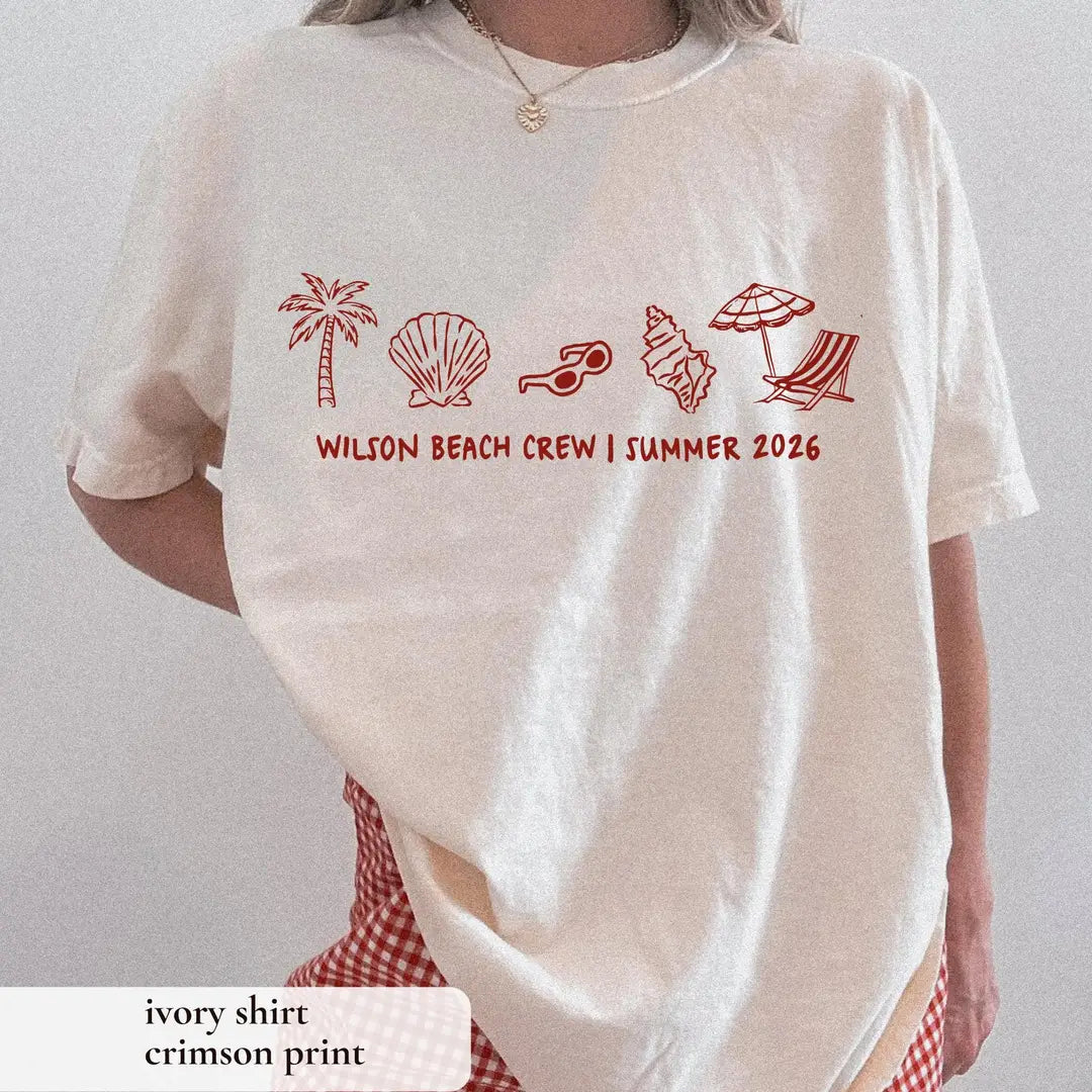 Woman in an Ivory Comfort Colors tee and red gingham skirt, crimson palm, shell and beach chair icons above Wilson Beach Crew