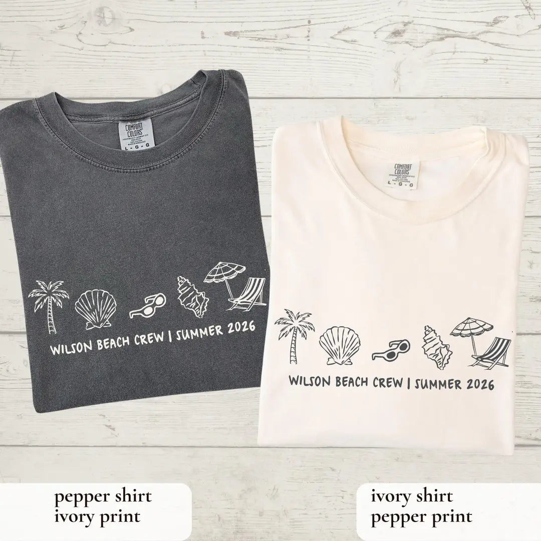 Folded Pepper and Ivory Comfort Colors tees on whitewashed wood, each with a row of beach icons and Summer 2026 line