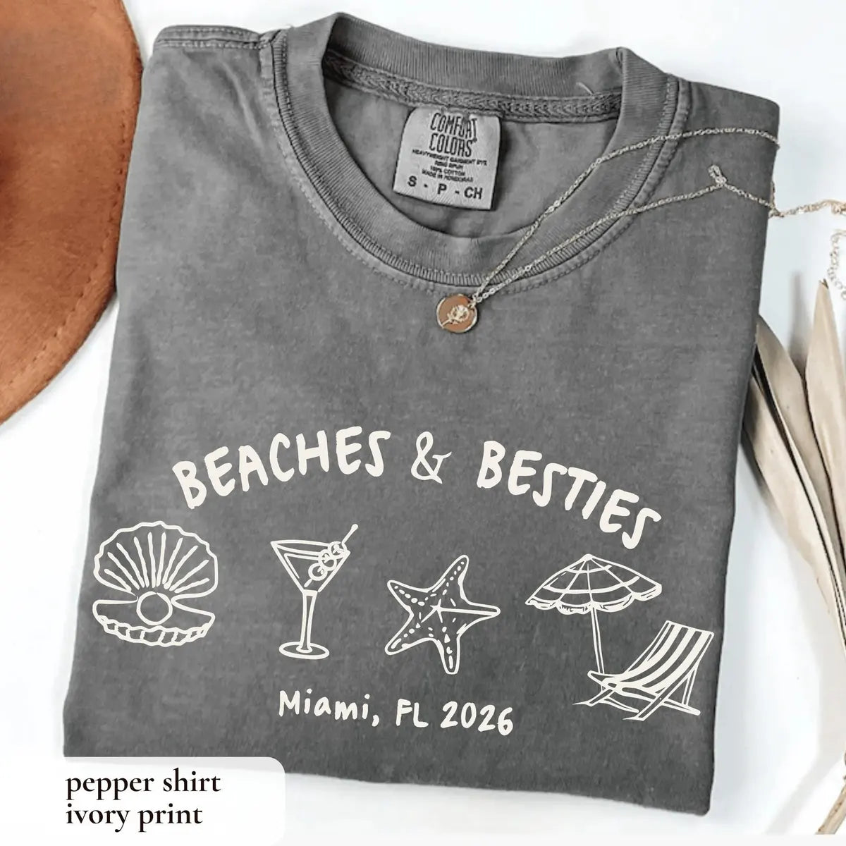 Folded Pepper Comfort Colors tee with an ivory arched beaches and besties, shell, martini and starfish above Miami, FL 2026