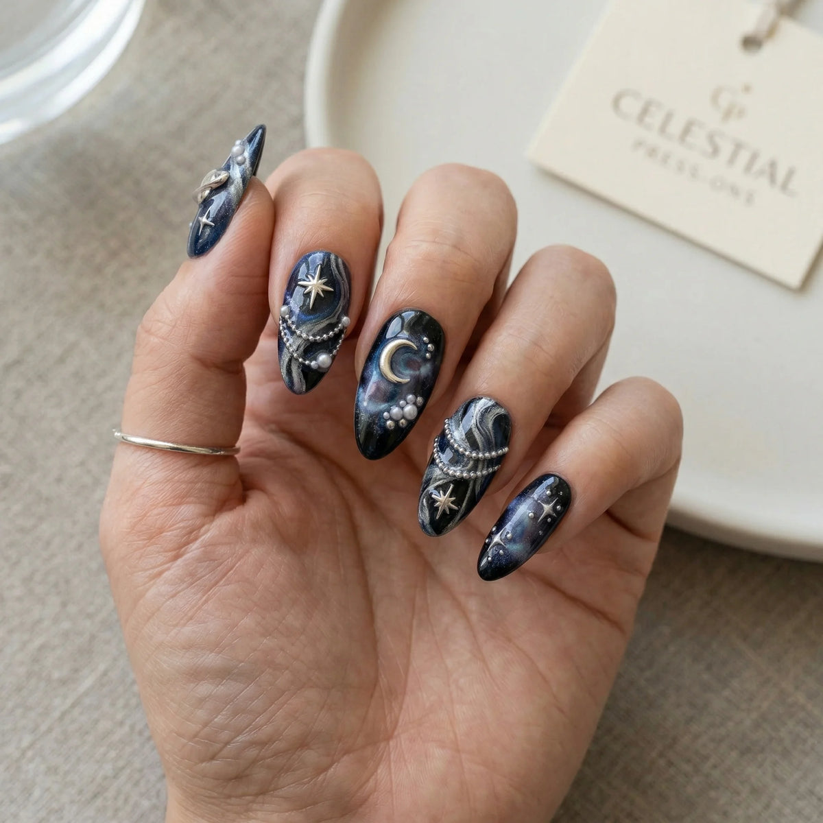 black hand painted almond medium press on nails silver planet saturn lifestyle 02