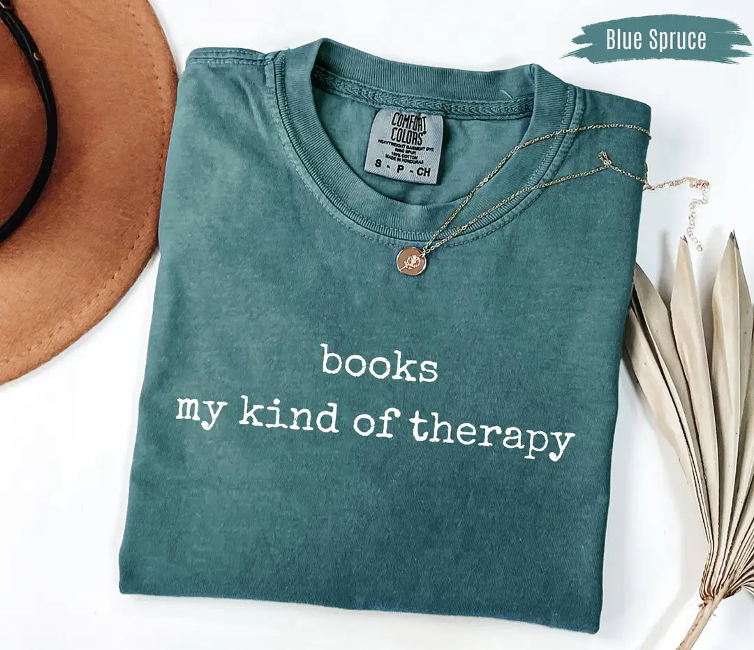 Blue Spruce Comfort Colors T-shirt with white 'books my kind of therapy' lettering, folded mockup.