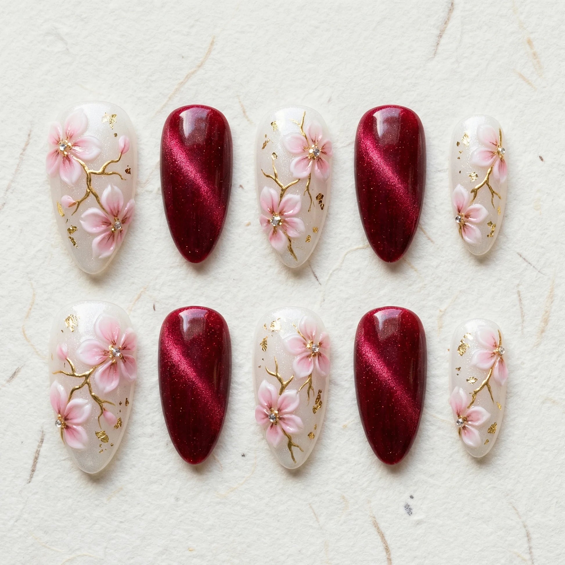 burgundy cat eye hand painted stiletto medium press on nails pink sakura flat lay 01