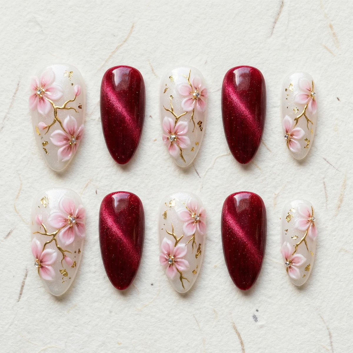 burgundy cat eye hand painted stiletto medium press on nails pink sakura flat lay 01