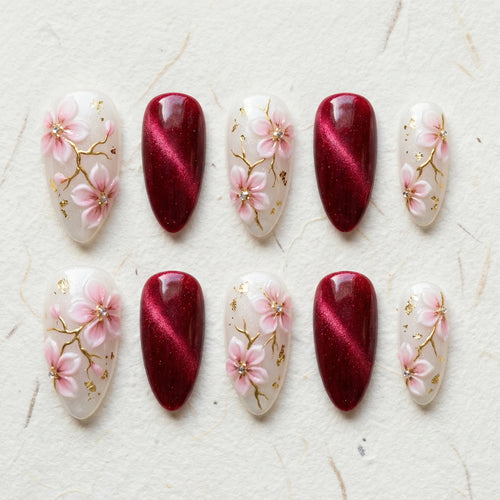 burgundy cat eye hand painted stiletto medium press on nails pink sakura flat lay 01