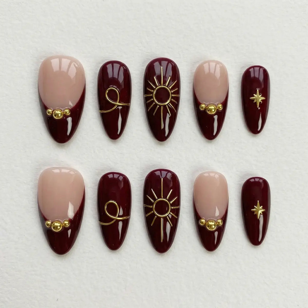 burgundy french tip almond press on nails gold celestial sun star flat lay 01