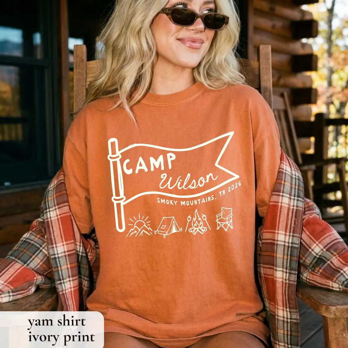 Woman in a Yam orange Comfort Colors tee with a plaid blanket on her arm, ivory Camp Wilson pennant, Smoky Mountains, TN 2026