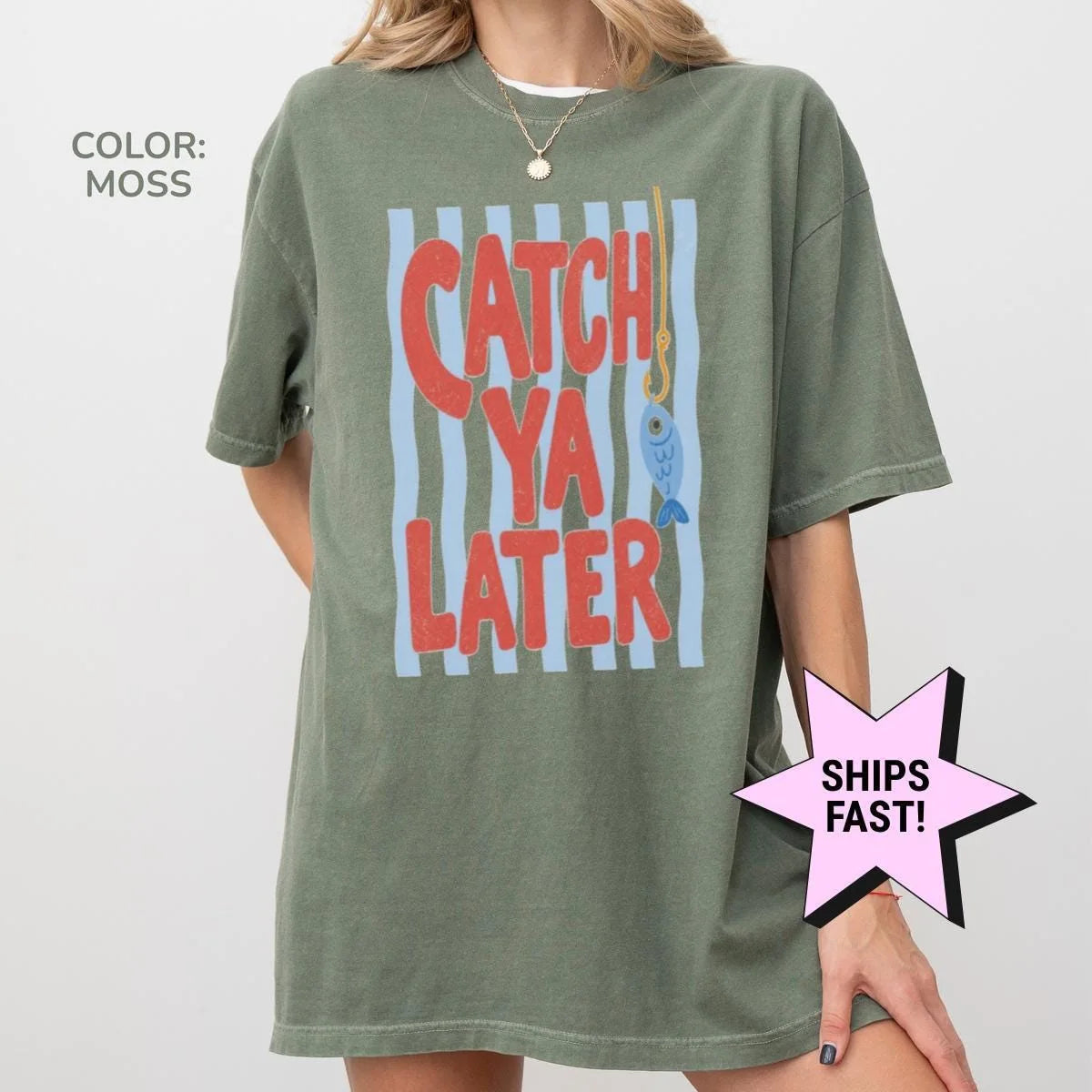 Woman in a Moss green Comfort Colors tee, hand on hip, with the red catch ya later text and a small blue fish