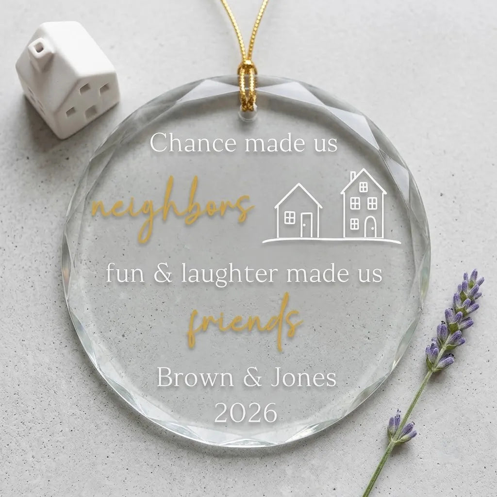 Clear glass round ornament laid flat on festive wooden surface with pine branches, pinecones and holiday decorations surrounding the neighbor friendship design