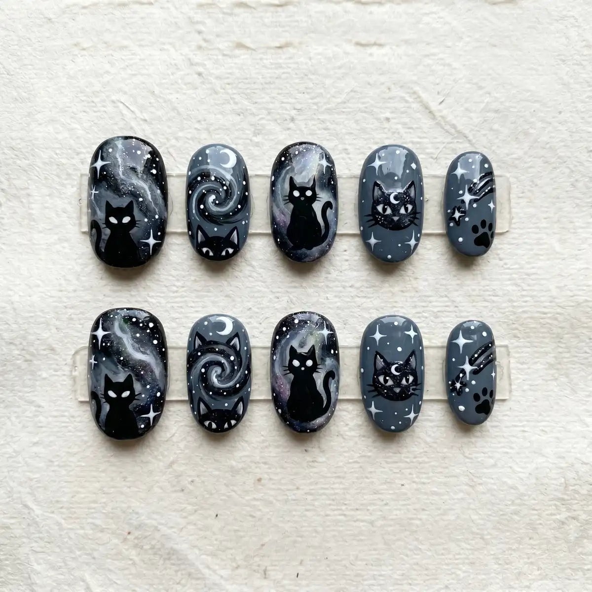 charcoal grey hand painted oval short press on nails galaxy cat flat lay 01