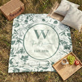 Close-up of the personalized chinoiserie floral toile woven blanket with monogram and fringe detail