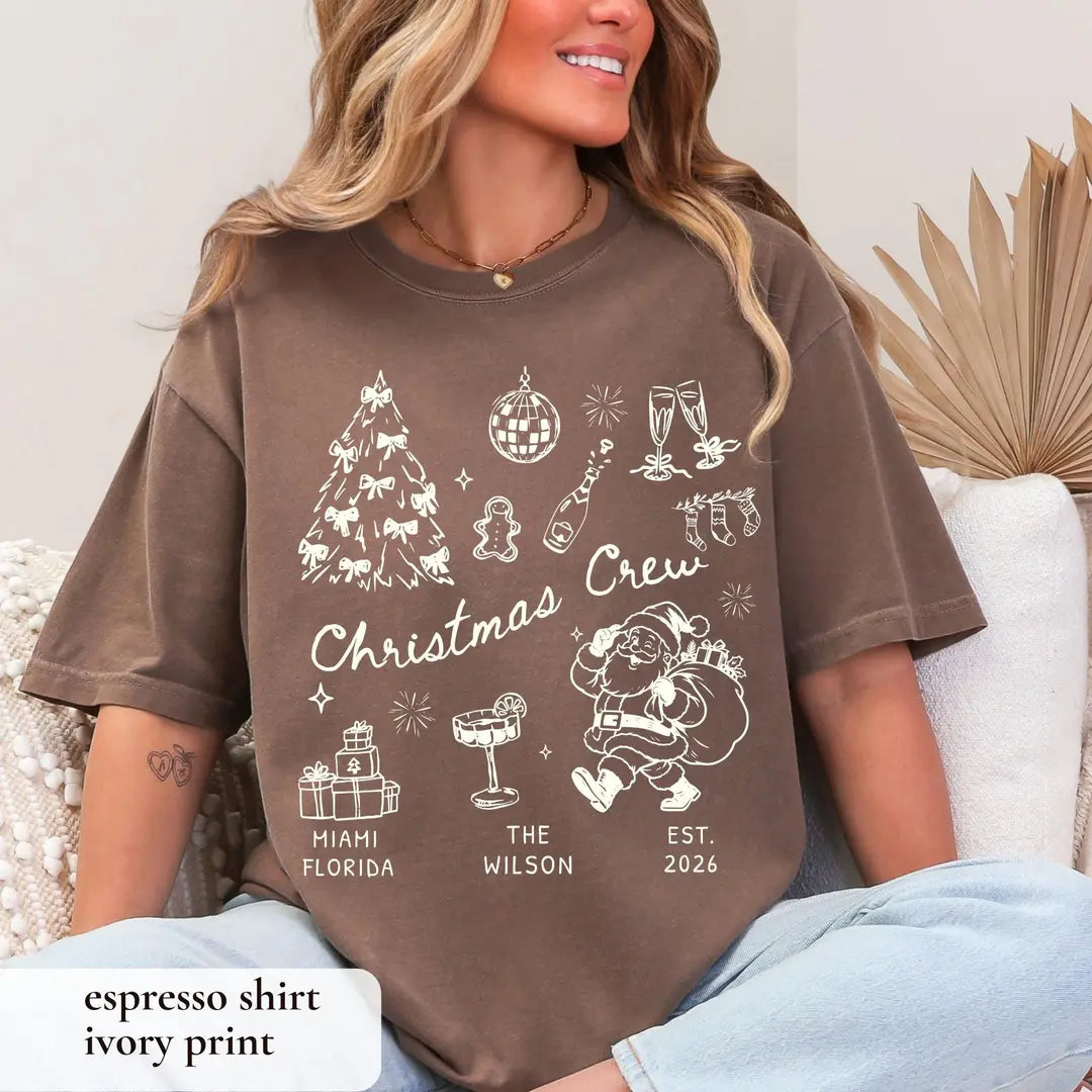 Woman in an Espresso brown Comfort Colors tee on a couch, ivory christmas crew with bow tree, cocktail and retro santa