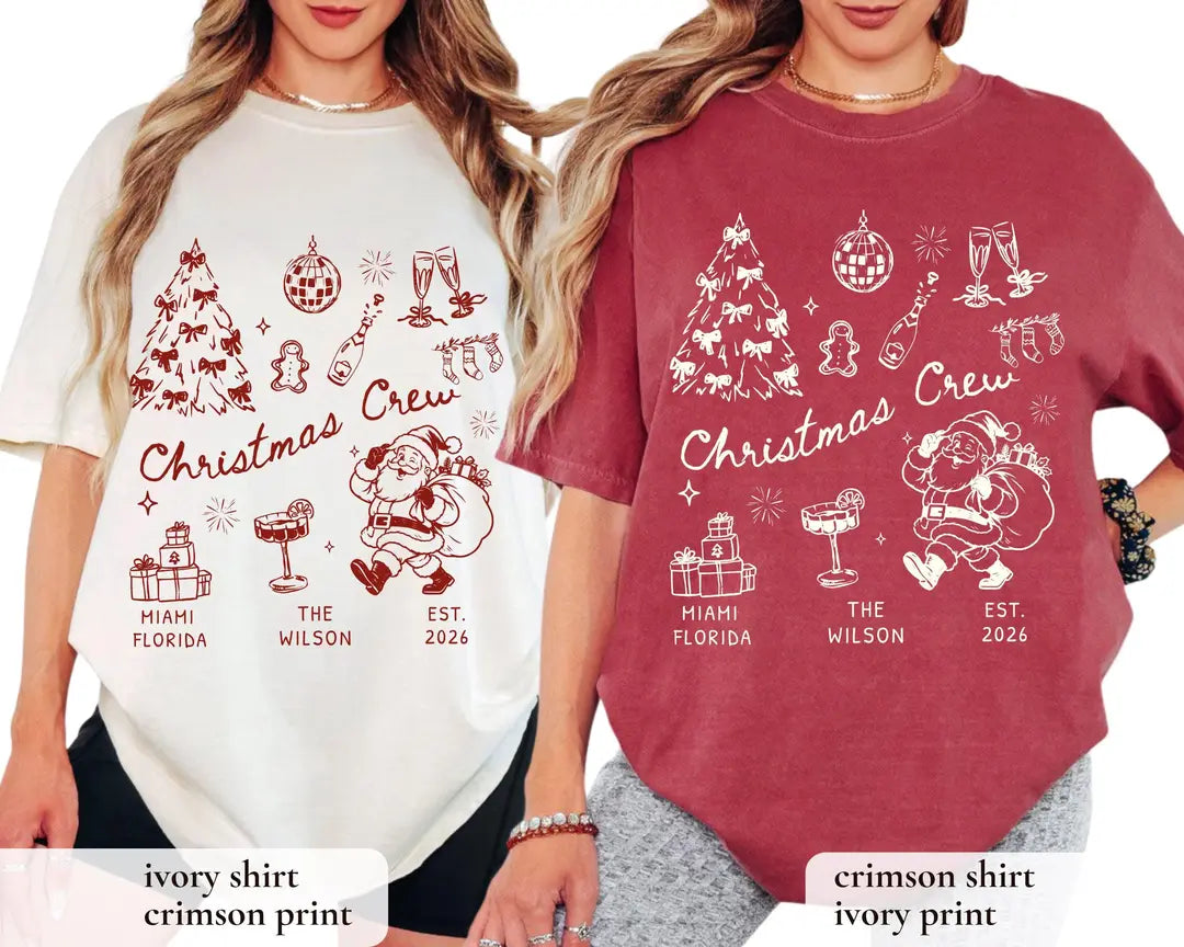 Two women in Ivory and Crimson Comfort Colors tees, each with christmas crew script, bow tree, cocktail and retro santa