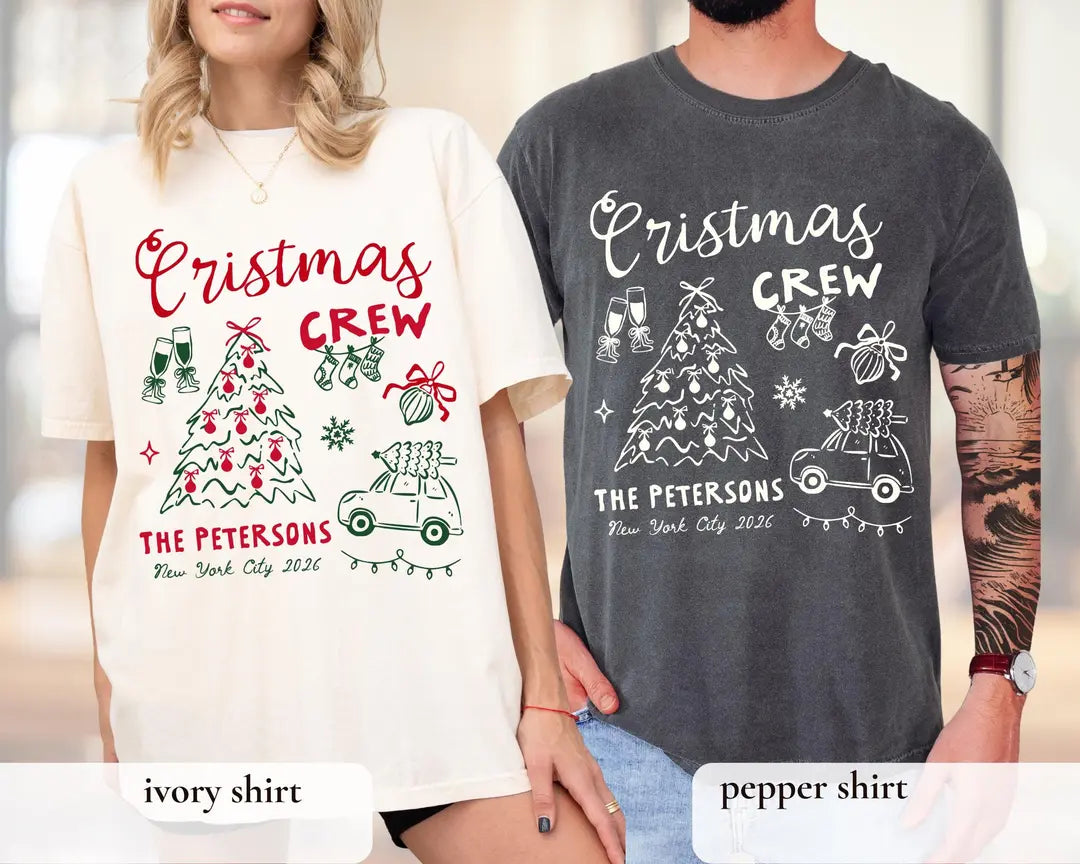 Woman in an Ivory and man in a Pepper Comfort Colors tee, crew script over a tree, snowflake and a car carrying a tree