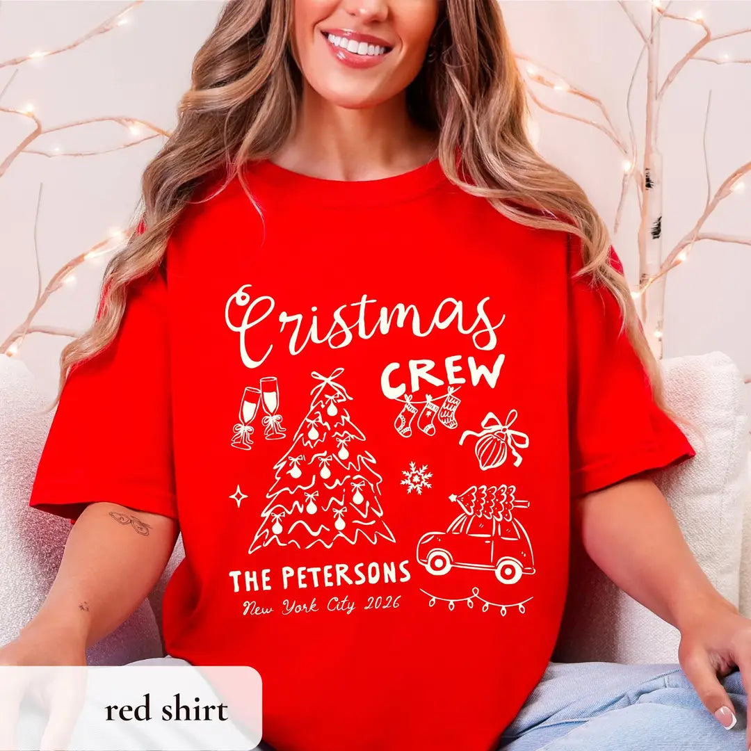 Smiling woman in a Red Comfort Colors tee in a bright room, white crew script with a tree, car and The Petersons