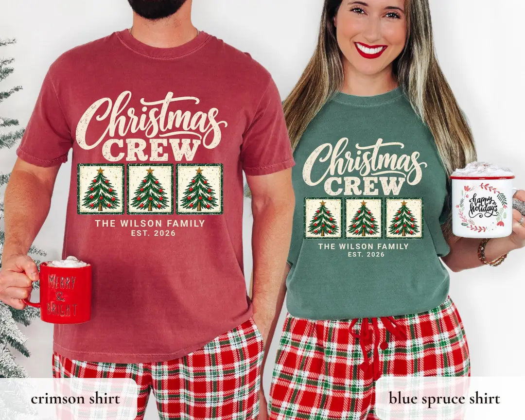 Man in a Crimson and woman in a Blue Spruce Comfort Colors tee with mugs and plaid pants, cream Christmas Crew, three trees