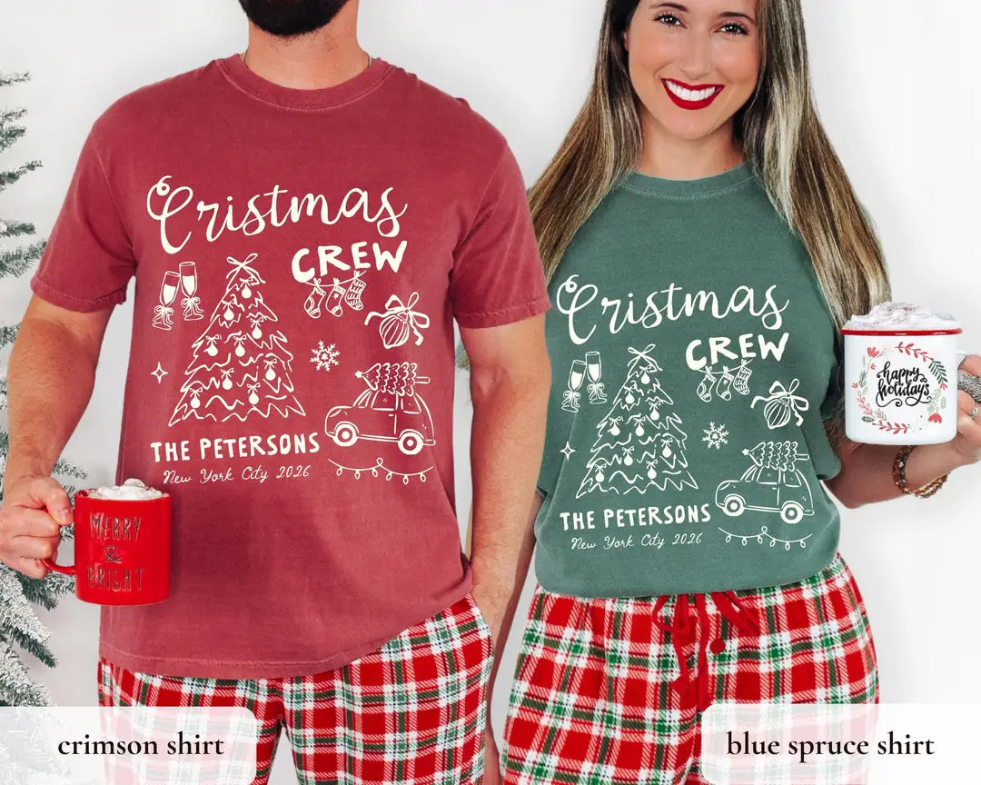 Man in a Crimson and woman in a Blue Spruce Comfort Colors tee holding holiday mugs, white crew script, tree and car design