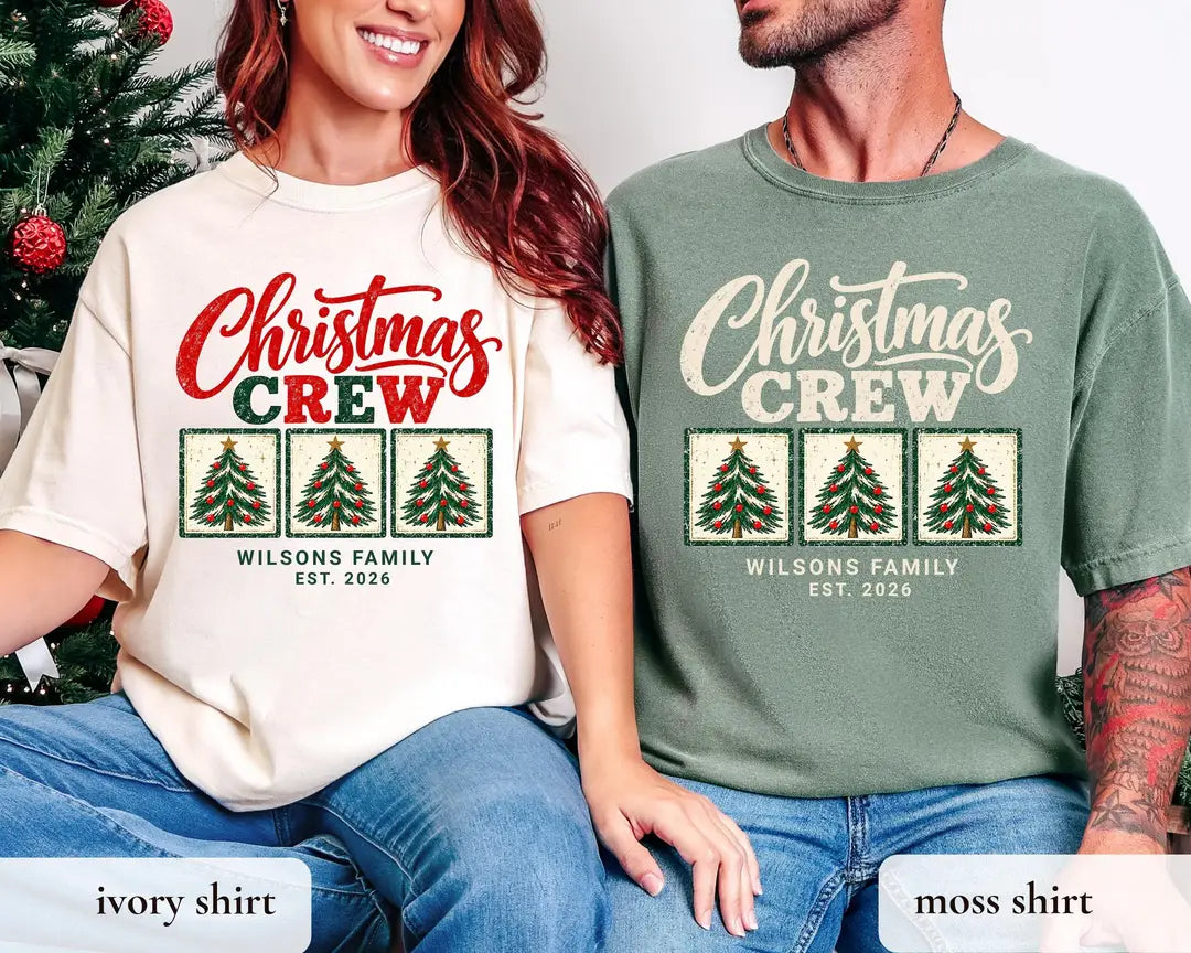 Woman and man in Ivory and Moss Comfort Colors tees by a christmas tree, Christmas Crew above three framed trees