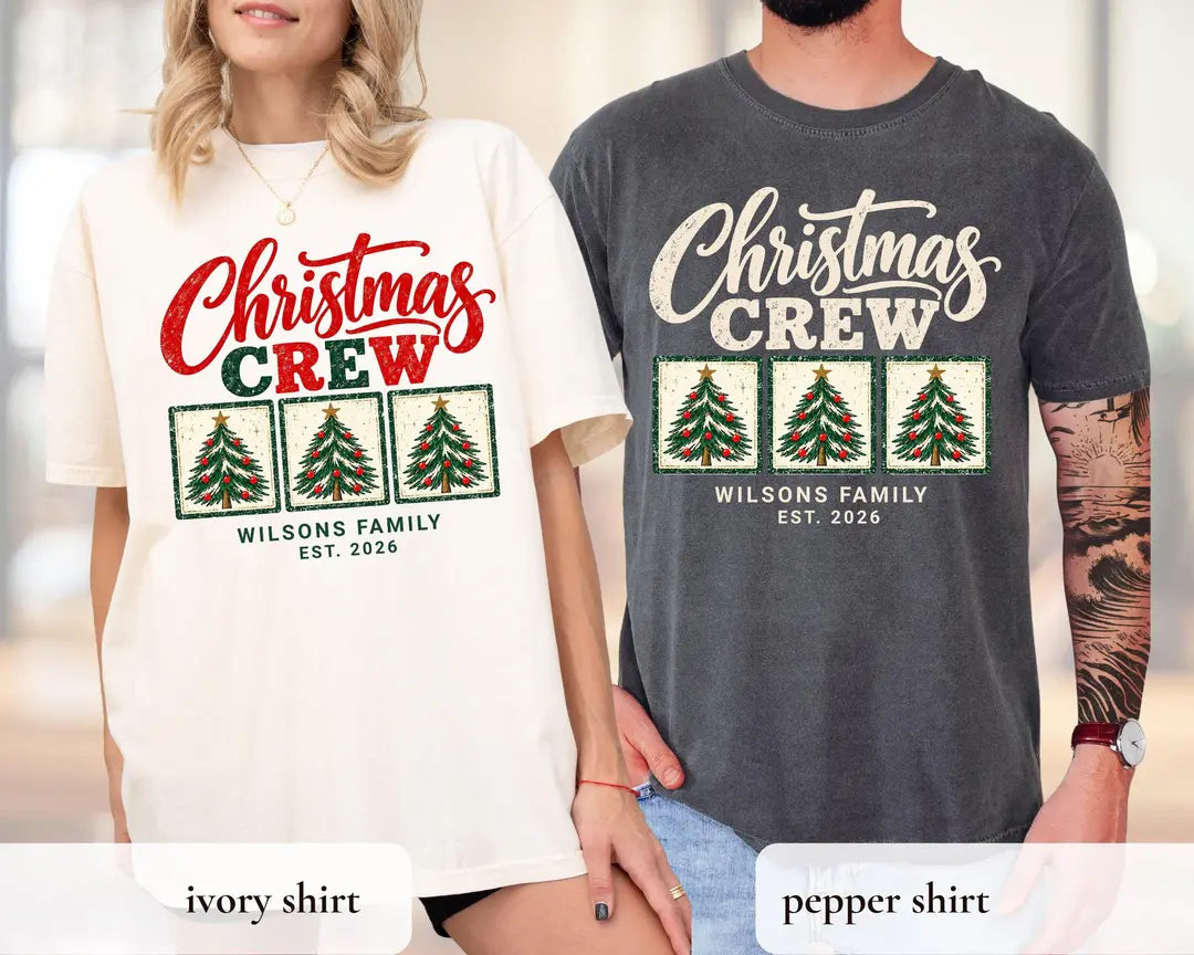 Woman and man in Ivory and Pepper Comfort Colors tees, Christmas Crew above three framed trees and Wilsons Family Est. 2026