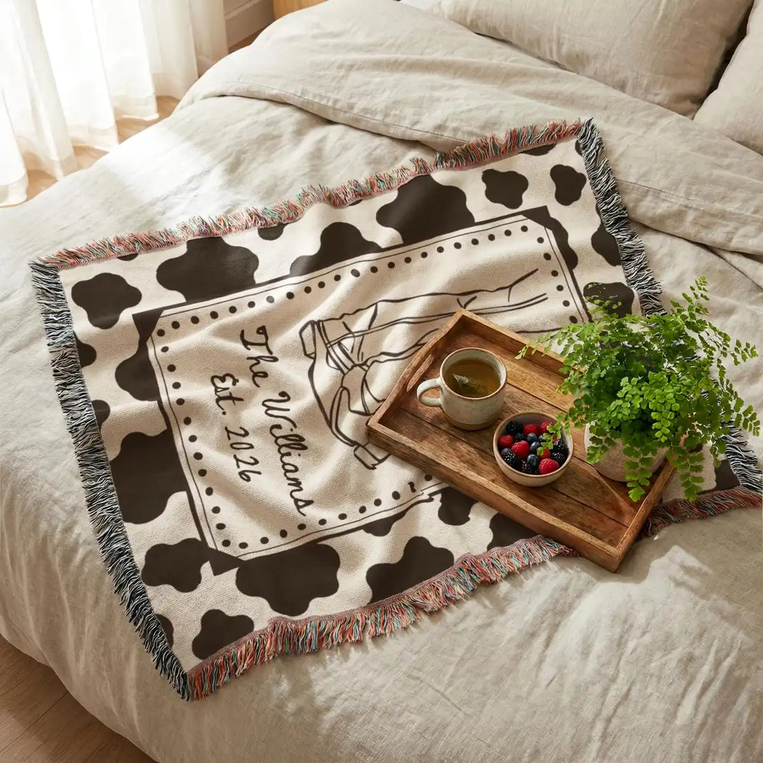 Personalized cow print western woven blanket shown in a styled room setting