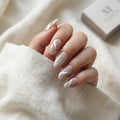 cream beige cat eye almond long press on nails white swirl flat lay 01