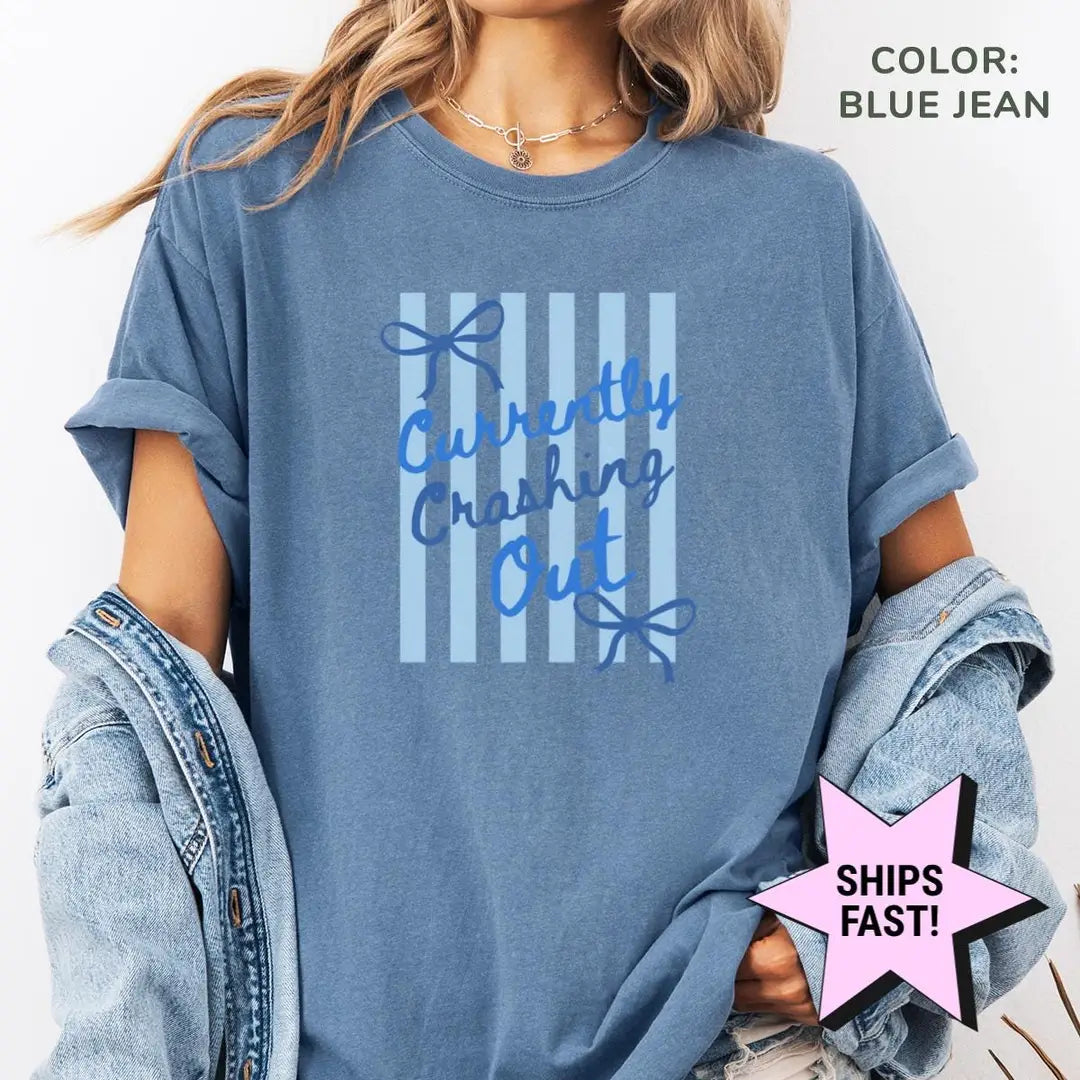 Woman in a Blue Jean Comfort Colors tee and a denim jacket with blue currently crashing out and bows over light stripes