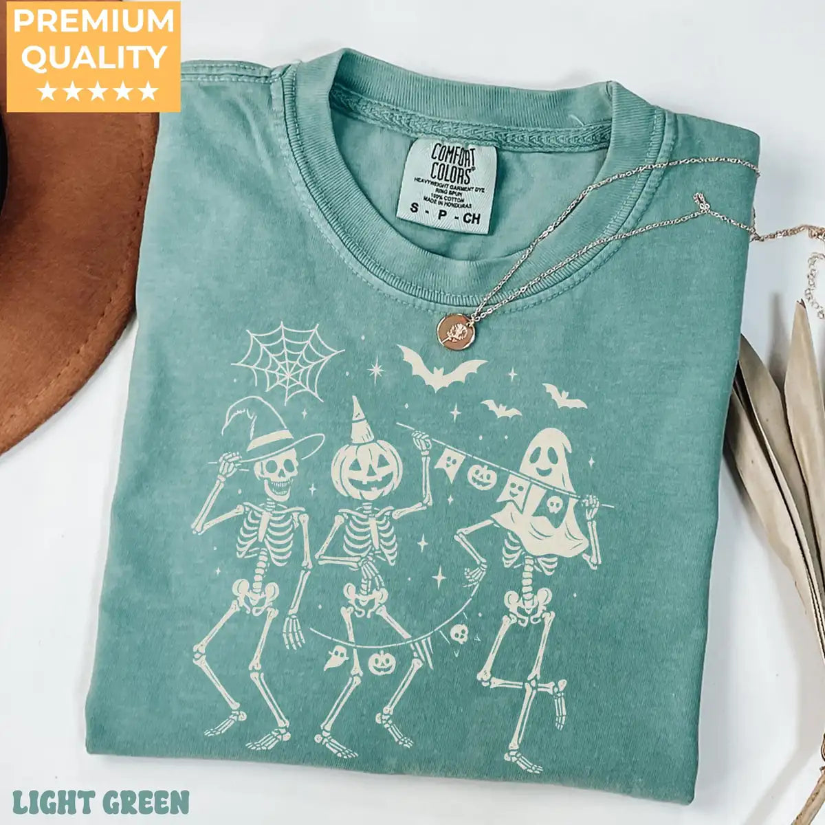 Comfort Colors T-shirt in Yam color featuring dancing skeletons holding banner graphic