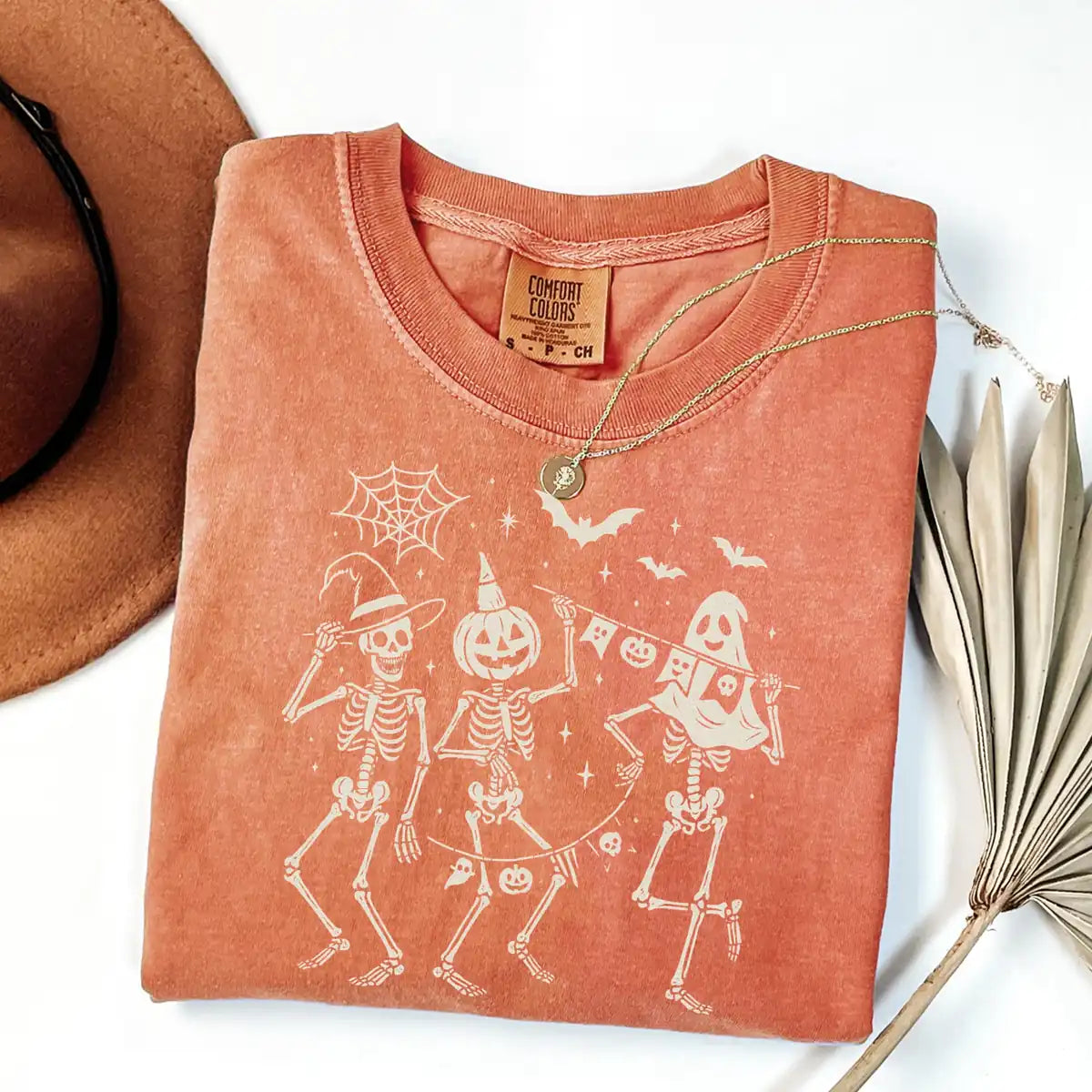 Comfort Colors T-shirt in Crunchberry color featuring dancing skeletons holding banner graphic