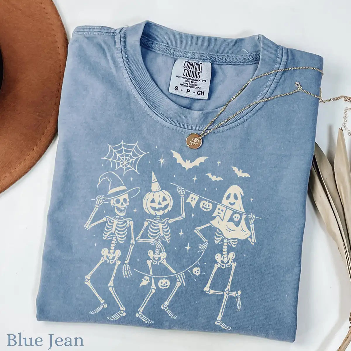 Comfort Colors T-shirt in Ivory color featuring dancing skeletons holding banner graphic