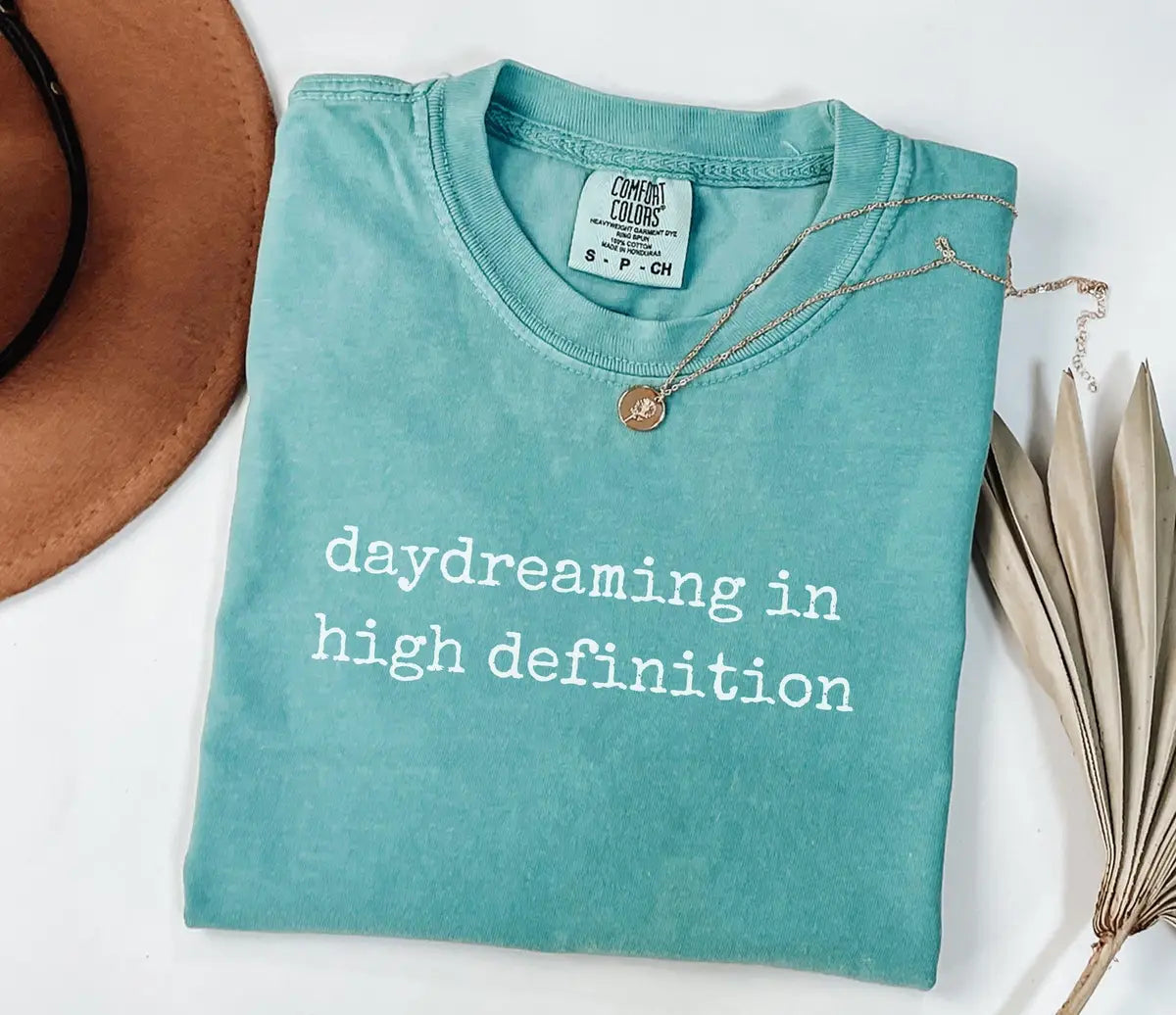 Seafoam Comfort Colors T-shirt with white Daydreaming in High Definition lettering.