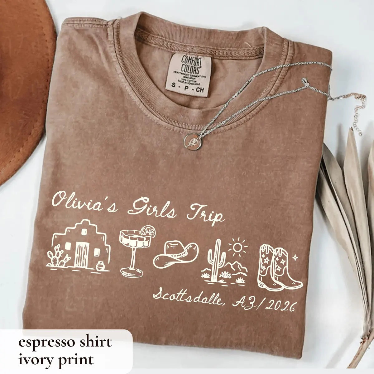 Folded Espresso brown Comfort Colors tee with ivory Olivia's Girls Trip script, margarita, cowboy hat and cowboy boots