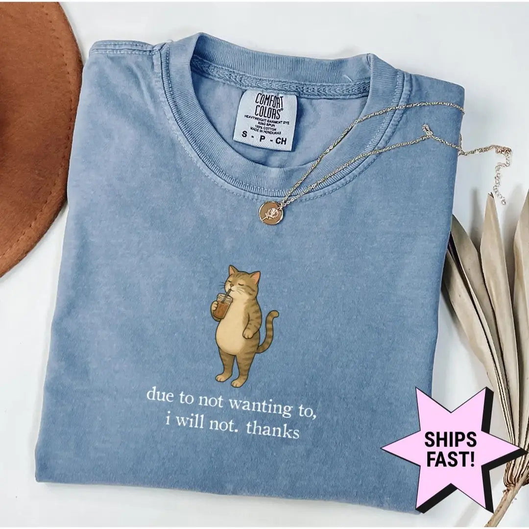 Folded Blue Jean Comfort Colors tee with a standing tabby sipping a drink above the sarcastic quote, necklace at the collar